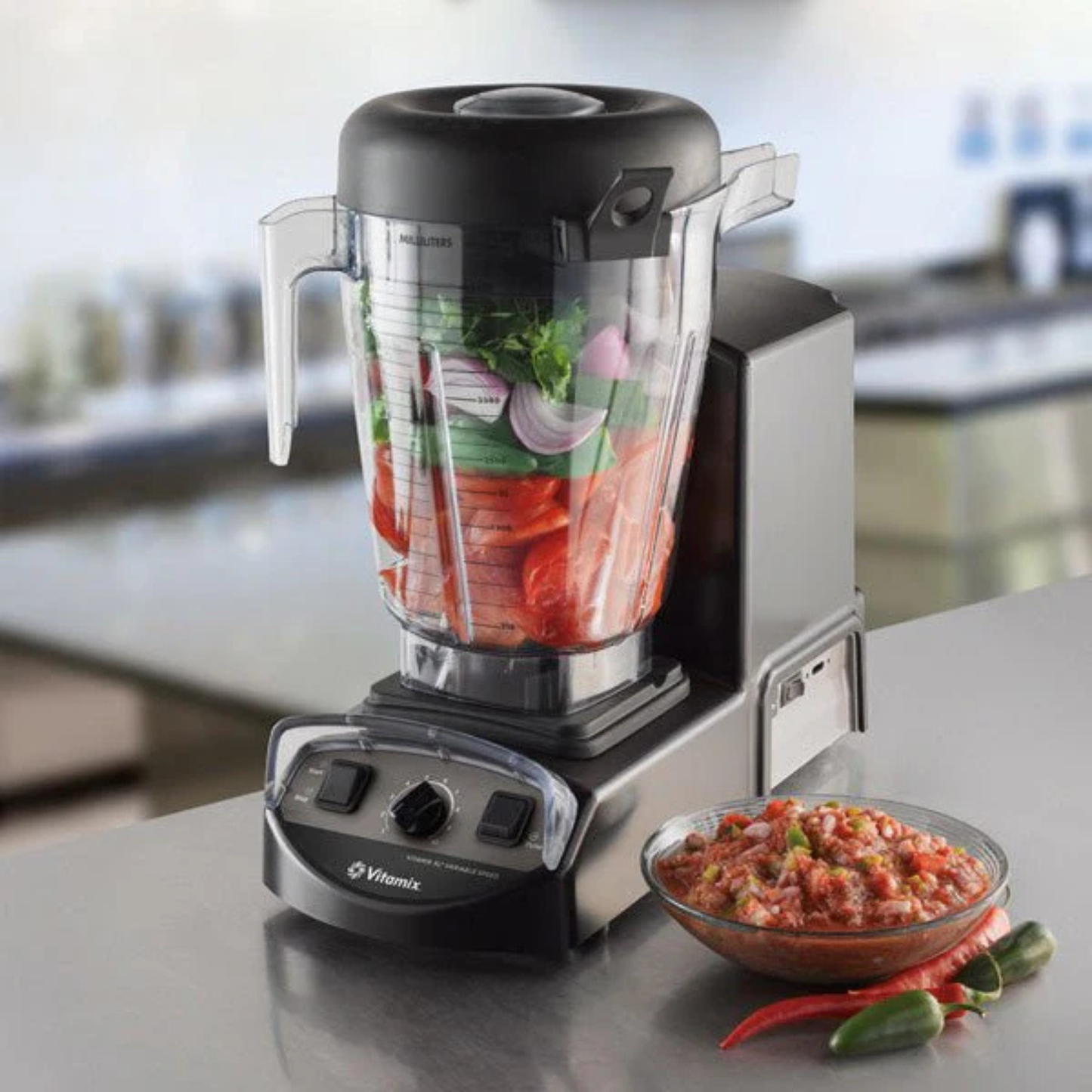 Vitamix XL Food Blender 5.6L | Blenders Direct with ingredients inside on a kitchen counter, next to a bowl of salsa.