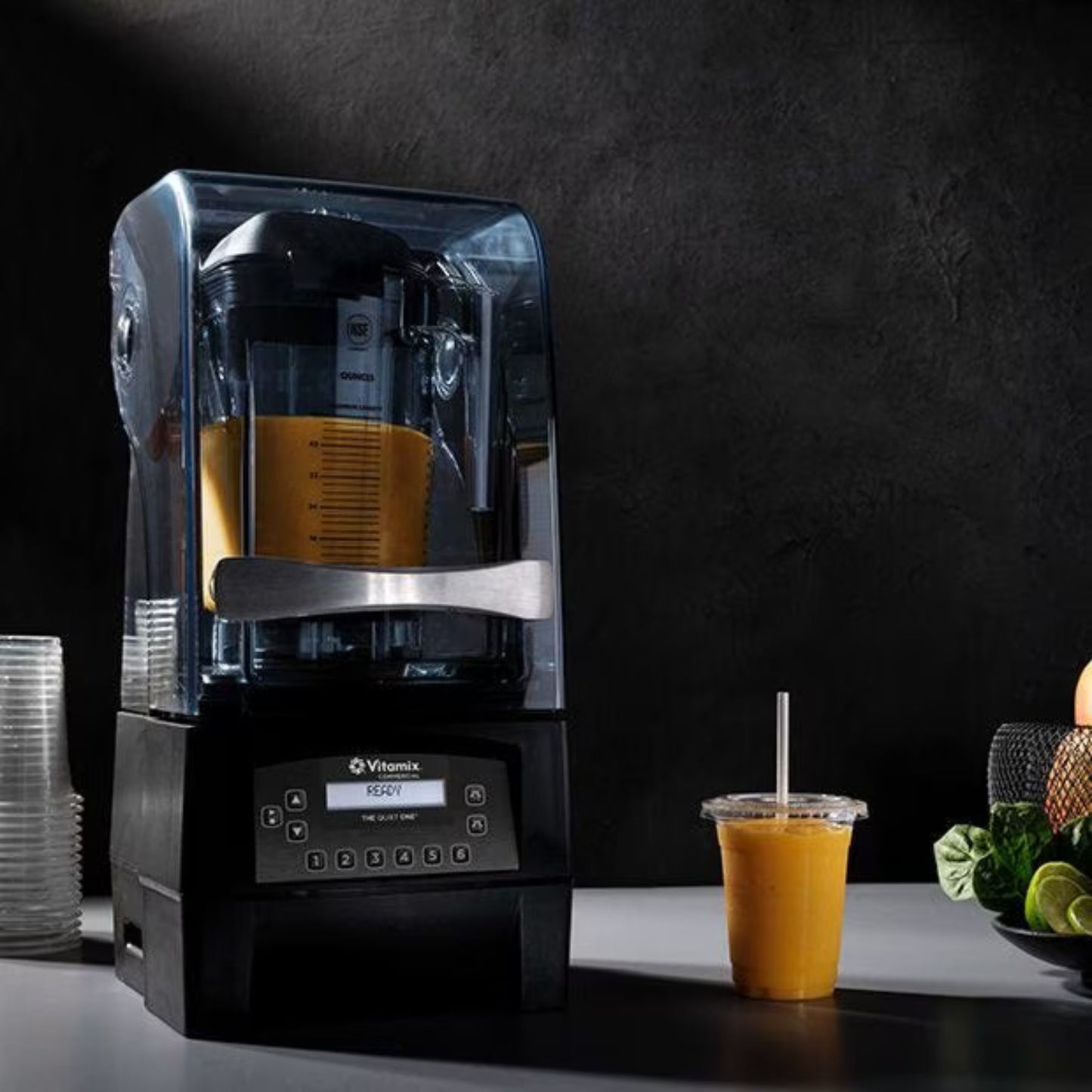 Blender with a smoothie and ingredients on a dark background